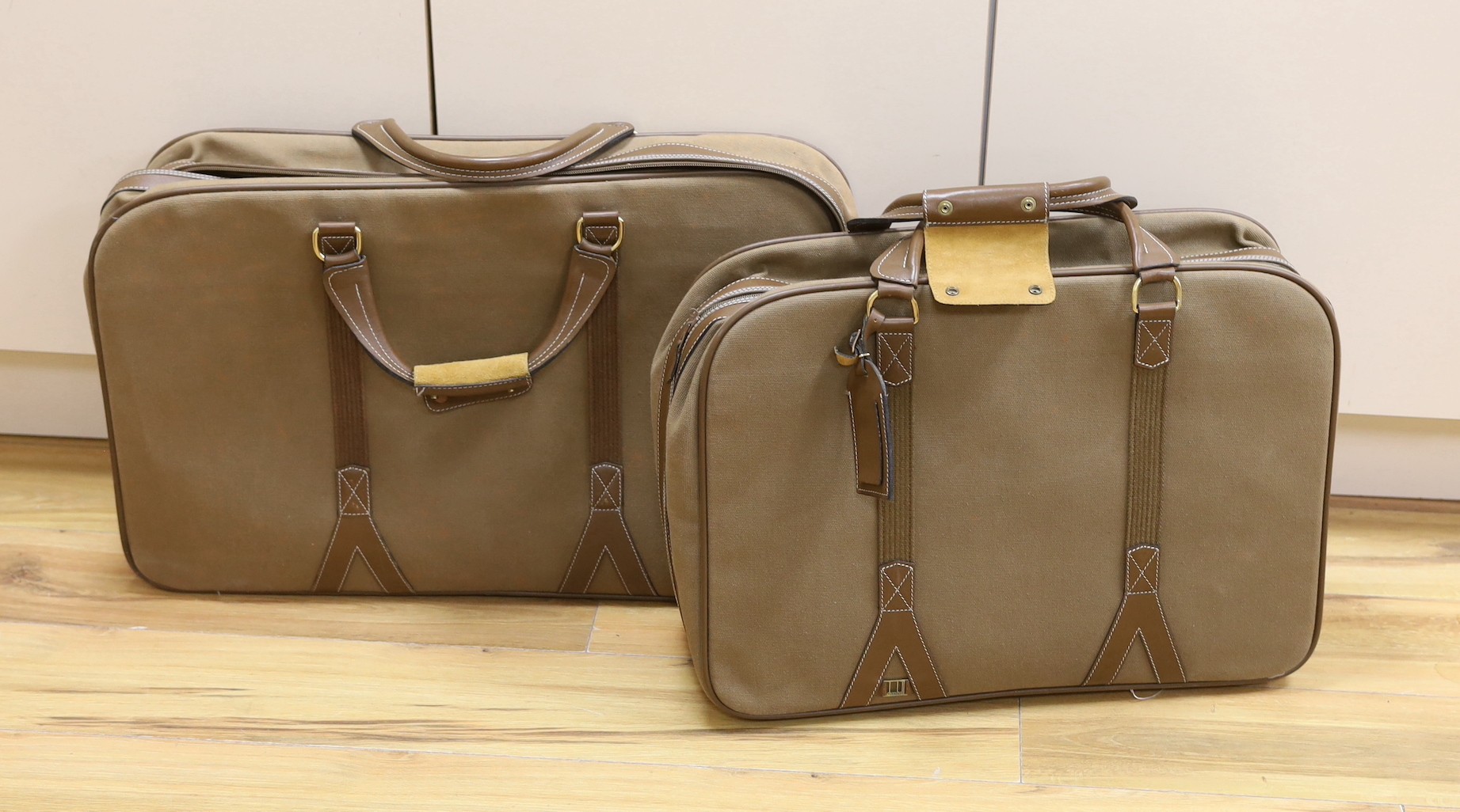 Two 1980's soft canvas Dunhill suit cases, largest 65 cms wide x 42 ms high.